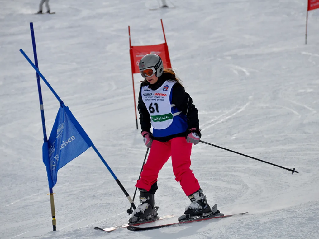 Skifahrerin mit Startnummer 61 in rosa Hose am Tor.